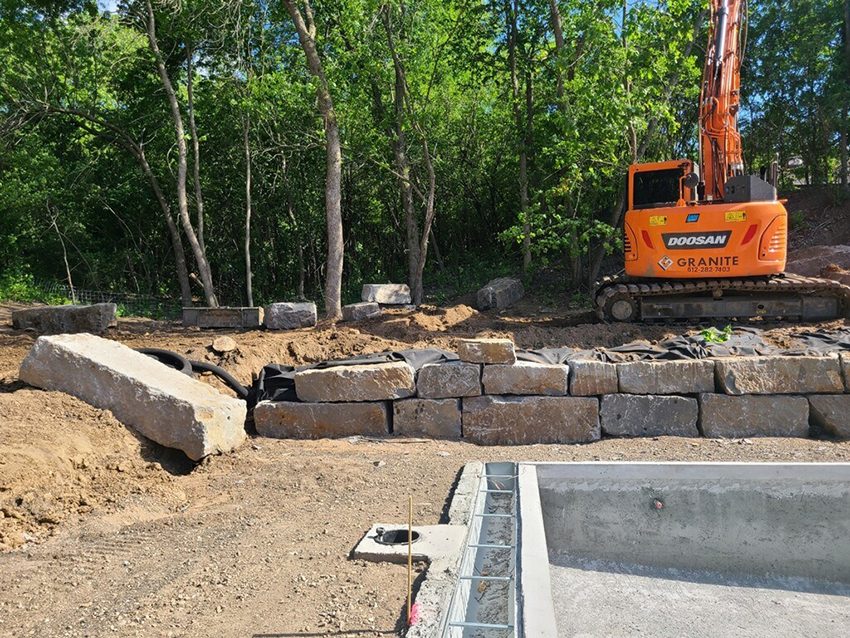 Equipment Residential Granite Boulder Retaining Wall Being Built Besid | Granite Companies MN