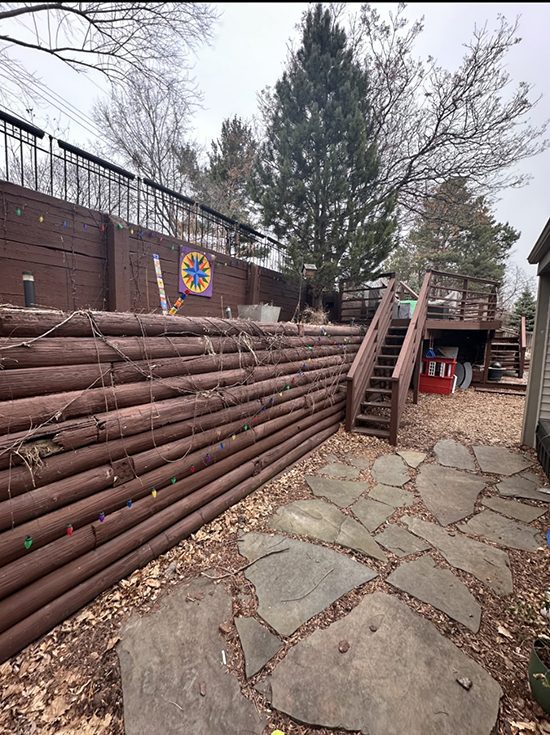Residential backyard with old wooden retaining wall before replacement | Granite Companies MN