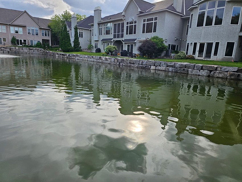 Residential neighborhood lake granite wall after replacement | Granite Companies MN